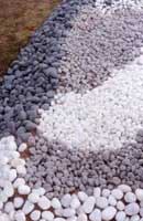 Different coloured and sized pebbles and gravels can be used to create interesting colour contrasts