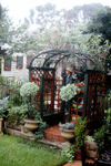 As you move into the front garden, a glance through an arch reveals a brick path leading to the sundial.