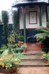 The backyard gazebo is gradually revealed as you move further through the rear garden.