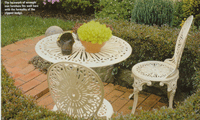 Laceworked wrought iron furniture and clipped hedge.